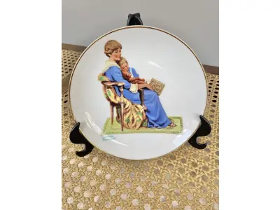 LOTE 175 - 01 PRATO DE COLECIONADOR INTITULADO "HORA DE DORMIR" É INSPIRADO NA OBRA DE NORMAN ROCKWELL E FAZ PARTE DA MARCA MUSEUM COLLECTIONS INC. APRESENTA UM DESIGN CHARMOSO QUE RETRATA A ROTINA DA HORA DE DORMIR DE UMA CRIANÇA, COM UM TOQUE VINTAGE QUE O TORNA PERFEITO PARA TODAS AS OCASIÕES. O PRATO TEM 16 CM DE DIÂMETRO. ESTE ITEM FOI FABRICADO NO JAPÃO DURANTE A DÉCADA DE 1980 E É UM ÓTIMO COMPLEMENTO PARA QUALQUER COLEÇÃO DE ITENS DECORATIVOS COLECIONÁVEIS. O TEMA DO PRATO É A HORA DE DORMIR, E É PERFEITO PARA QUEM APRECIA A CULTURA AMERICANA E ITENS VINTAGE. SUPORTE DO PRATO NÃO ESTÁ INCLUÍDO. ITEM COMPRADO EM GARAGENS DE ANTIGUIDADES NOS EUA. (NO ESTADO) ATENÇÃO! FAZER A VISITAÇÃO ANTES DE ARREMATAR, NÃO SABEMOS SE FUNCIONA, LEILÃO NÃO TEM GARANTIA E NEM DEVOLUÇÃO, SUJEITO A POSSÍVEIS AVARIAS VISÍVEIS/OCULTAS E/OU AUSÊNCIA DE COMPONENTES.