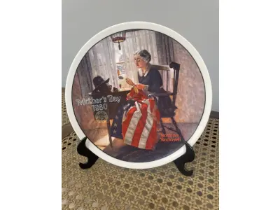 LOTE 311 - 01 PRATO COLECIONÁVEL DE NORMAN ROCKWELL DA DÉCADA DE 1980. O MAIS GRANDE 1854 KNOWLES PLACA NÚMERO 14010 B DA PRIMEIRA EDIÇÃO LIMITADA, "A MOTHER'S PRIDE NORMAN ROCKWELL", "EM PORTUGUES  ORGULHO DE UMA MÃE "A QUINTA DE UMA SÉRIE ANUAL PARA O DIA DAS MÃES. CERTIFICADA PELA ROCKWELL SOCIET MERICA. FEITA EM EDIÇÃO LIMITADA PERMANENTEMENTE EM 9 DE MAIO DE 1980, POR KNOWLES, A EMPRESA MAIS ANTIGA DA AMÉRICA EM PORCELANA FINA. SOCIEDADE DE PFICIAR COPYRIGHT 1980 R.S.OF A. NÚMERO DO IRMÃO: 84-70-2.6.EM EXCELENTE ESTADO, POSSUI A CAIXA ORIGINAL E OS DOCUMENTOS. O SUPORTE DO PRATO NÃO ESTÁ INCLUÍDO. PEÇA COMPRADA EM GARAGEM DE ANTIGUIDADES NOS EUA. SUPORTE PARA PRATO NÃO INCLUÍDO NESTA VENDA. (NO ESTADO) ATENÇÃO! FAZER A VISITAÇÃO ANTES DE ARREMATAR, NÃO SABEMOS SE FUNCIONA, LEILÃO NÃO TEM GARANTIA E NEM DEVOLUÇÃO, SUJEITO A POSSÍVEIS AVARIAS VISÍVEIS/OCULTAS E/OU AUSÊNCIA DE COMPONENTES.