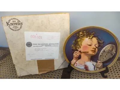 LOTE 147 - 01 RARO PRATO PARA AMANTES E COLECIONADORES DE NORMAN ROCKWELL! ESTE É UM PRATO COLECIONÁVEL DE PORCELANA VINTAGE DE EDIÇÃO LIMITADA. "MAKING BELIEVE AT THE MIRROR" DE NUMERO 16209M É A QUARTA PLACA DA COLEÇÃO DE EDIÇÃO LIMITADA INTITULADA ROCKWELL'S REDISCOVERED WOMEN, UMA SÉRIE QUE OFERECE UMA RETROSPECTIVA ÚNICA DAS OBRAS DE NORMAN ROCKWELL. ESTA OBRA É OFICIALMENTE CERTIFICADA PELA ROCKWELL SOCIETY OF AMERICA. FOI ENCONTRADA EM UM ARMÁRIO DURANTE A VENDA DE UMA PROPRIEDADE, APÓS MUITOS ANOS GUARDADA.  CAIXA ORIGINAL E CERTIFICADO DE AUTENTICIDADE DA PEÇA  O PRATO MEDE 21,5 CM DE DIÂMETRO.  SUPORTE PARA PRATO NÃO INCLUÍDO NESTA VENDA. (NO ESTADO) ATENÇÃO! FAZER A VISITAÇÃO ANTES DE ARREMATAR, NÃO SABEMOS SE FUNCIONA, LEILÃO NÃO TEM GARANTIA E NEM DEVOLUÇÃO, SUJEITO A POSSÍVEIS AVARIAS VISÍVEIS/OCULTAS E/OU AUSÊNCIA DE COMPONENTES.