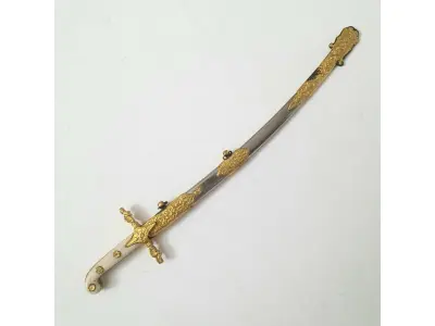 LOTE 115 - 01 MINIATURA DE ESPADA DA MARINHA EM METAL. LÂMINA CINZELADA DE  DUQUE DE CAIXAS  RJ. DA DECADA DE 80 BAINHA DE METAL COM APLIQUES EM METAL DOURADO,COM 15 CM DE CUMPRIMENTO. (NO ESTADO) ATENÇÃO! FAZER A VISITAÇÃO ANTES DE ARREMATAR, NÃO SABEMOS SE FUNCIONA, LEILÃO NÃO TEM GARANTIA E NEM DEVOLUÇÃO, SUJEITO A POSSÍVEIS AVARIAS VISÍVEIS/OCULTAS E/OU AUSÊNCIA DE COMPONENTES.