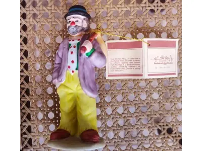 LOTE 192 - 01 ESTATUETA DE PALHAÇO DE CERÂMICA VINTAGE DA COLEÇÃO FLAMBRO DE EMMETT KELLY JR,ESTILO HOBO, COM ALÇA OU ALÇA. ETIQUETA ORIGINAL. EXCELENTE ESTADO, SEM LASCAS, RACHADURAS EM ÓTIMO ESTADO PEÇA RARA ITEM LANÇADOS ANOS 90 NOS EUA  CM DE ALTURA E UMA BASE DE 15 ​​CM. COM  SUA ASSINATURA NA PARTE INFERIOR JUNTO COM "EXCLUSIVAMENTE DA FLAMBRO EMPRESA FAMOSA NOS EUA DECADA DE 90, COMPRADAS EM LOJAS DE ANTIGUIDADES DOS EUA. (NO ESTADO) ATENÇÃO! FAZER A VISITAÇÃO ANTES DE ARREMATAR, NÃO SABEMOS SE FUNCIONA, LEILÃO NÃO TEM GARANTIA E NEM DEVOLUÇÃO, SUJEITO A POSSÍVEIS AVARIAS VISÍVEIS/OCULTAS E/OU AUSÊNCIA DE COMPONENTES.