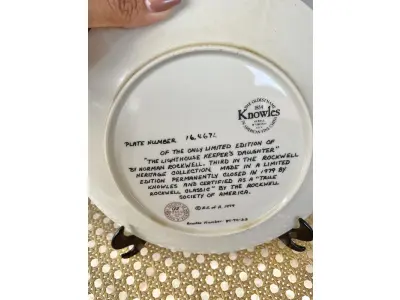 LOTE 131 - 01 PRATO NORMAN ROCKWELL.UM PEDAÇO DA HISTÓRIA AMERICANA COM ESTE PRATO DE COLECIONADOR DE  EDIÇÃO LIMITADA, COM UMA BELA ILUSTRAÇÃO DE NORMAN ROCKWELL DE 1979. ESTE PRATO RETRATA LIGHTHOUSE KEEPER’S DAUGHTER "A FILHA DO FAROLEIRO" E É FEITO NOS ESTADOS UNIDOS. PERFEITO PARA FÃS DA ICÔNICA OBRA DE ROCKWELL, ESTE PRATO DE COLECIONADOR É UM ITEM ESSENCIAL PARA QUALQUER COLEÇÃO. ADICIONE ESTA PEÇA DESLUMBRANTE À SUA COLEÇÃO HOJE MESMO E ADMIRE OS DETALHES COMPLEXOS E AS BELAS CORES QUE FAZEM DESTE PRATO UMA OBRA DE ARTE. COM CERTIFICADO DE AUTENTICIDADE. ITEM COMPRADO E GARAGENS DE ANTIGUIDADES NOS EUA. SUPORTE PARA PRATO NÃO INCLUÍDO NESTA VENDA. (NO ESTADO) ATENÇÃO! FAZER A VISITAÇÃO ANTES DE ARREMATAR, NÃO SABEMOS SE FUNCIONA, LEILÃO NÃO TEM GARANTIA E NEM DEVOLUÇÃO, SUJEITO A POSSÍVEIS AVARIAS VISÍVEIS/OCULTAS E/OU AUSÊNCIA DE COMPONENTES.