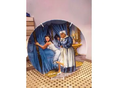 LOTE 296 - 01 PRATO O VENTO LEVOU  MAMMY LACING SCARLETT LINDO PRATO DE PORCELANA. ESTE É MAMMY LACING SCARLETT. ARTISTA RAYMOND KURSAR. ASSINADO NA FRENTE. QUINTA EDIÇÃO DE E O VENTO LEVOU 1982 EDWIN M KNOWLES. AUTORIZADO PELA MGM - EDIÇÃO LIMITADA. SELZNICK. PRATO BRADEX #84-K41-3.5. TODAS AS INFORMAÇÕES NO VERSO DO PRATO. TEM TODA A PAPELADA E CAIXA ORIGINAL. A CAIXA ORIGINAL ESTÁ EM BOAS CONDIÇÕES. PRATO EM PERFEITAS CONDIÇÕES. VIVIAN LEIGH E HATTIE MCDANIEL. MAMMY ESTÁ PREPARANDO SCARLETT PARA O GRANDE CHURRASCO DE 12 OAKS. LINDO QUARTO AZUL COM LUXUOSOS DETALHES DOURADOS. SCARLETT EM SEU ESPARTILHO. ESTE PRATO DE EDIÇÃO LIMITADA ESTÁ EM EXCELENTES CONDIÇÕES NA EMBALAGEM ORIGINAL E FOLHETO SERIA UMA ADIÇÃO FABULOSA À SUA COLEÇÃO. ESTES PRATOS SÃO EXTREMAMENTE COLECIONÁVEIS E NÃO SÃO MAIS FABRICADOS, O QUE OS TORNA UM BEM REALMENTE VALIOSO. VÊM COM UM CERTIFICADO DE AUTENTICIDADE E UM NÚMERO ÚNICO LIMITADO REGISTRADO PELO FABRICANTE.PEÇA COMPRADA EM GARAGEM DE ANTIGUIDADES NOS EUA. SUPORTE PARA PRATO NÃO INCLUÍDO NESTA VENDA.  (NO ESTADO) ATENÇÃO! FAZER A VISITAÇÃO ANTES DE ARREMATAR, NÃO SABEMOS SE FUNCIONA, LEILÃO NÃO TEM GARANTIA E NEM DEVOLUÇÃO, SUJEITO A POSSÍVEIS AVARIAS VISÍVEIS/OCULTAS E/OU AUSÊNCIA DE COMPONENTES.