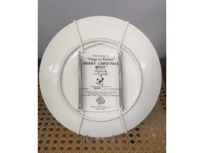 LOTE 284 - 01 PRATO VINTAGE PARA COLECIONADORES APRESENTA O HERÓI CANINO FAVORITO DE TODOS, BENJI,  MULBERRY "WAGS TO RICHES" DE BENJI, EM UMA EMOCIONANTE CENA NATALINA. O PRATO MEDE 21 CM DE DIÂMETRO E É FEITO DE PORCELANA ROYAL MANOR. ACOMPANHA UM CERTIFICADO DE AUTENTICIDADE E É UM ITEM ESSENCIAL PARA QUALQUER FÃ DE BENJI OU COLECIONADOR DE PRATOS DECORATIVOS. O PRATO ESTÁ EM EXCELENTE ESTADO E NÃO APRESENTA SINAIS DE DESGASTE OU DANOS. PRATO DE NUMERO 3838 DE UMA EDIÇAO LIMITADA A 15,500 PRATOS LANÇADOS NA EPOCA NOS EUA PELA CREATIVE WORD LTD.NÃO PERCA ESTA PEÇA ÚNICA DA CULTURA AMERICANA VINTAGE! PEÇA COMPRADA EM GARAGEM DE ANTIGUIDADES NOS EUA. SUPORTE PARA PRATO NÃO INCLUÍDO NESTA VENDA. (NO ESTADO) ATENÇÃO! FAZER A VISITAÇÃO ANTES DE ARREMATAR, NÃO SABEMOS SE FUNCIONA, LEILÃO NÃO TEM GARANTIA E NEM DEVOLUÇÃO, SUJEITO A POSSÍVEIS AVARIAS VISÍVEIS/OCULTAS E/OU AUSÊNCIA DE COMPONENTES.