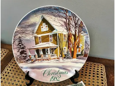 LOTE 157 - 01 LINDO PRATO DE NATAL DA SMUCKER'S COM 21 ,5 FAZIA PARTE DE UMA SÉRIE PARA COLECIONADORES E ERA INCLUÍDO EM UM PACOTE ANUAL DE PRESENTES DE NATAL CONTENDO UMA VARIEDADE DE GELEIAS E COMPOTAS DA SMUCKER'S. DAVID PROJETOU SEU PRIMEIRO PRATO PARA A SMUCKER'S EM 1972, COM OS PRIMEIROS DEZ PRATOS APRESENTANDO CENAS NATALINAS DE TODOS OS LUGARES, INCLUINDO A WILLIAMSBURG COLONIAL, A FILADÉLFIA HISTÓRICA, O VALE DO MISSISSIPPI E ATÉ MESMO A SUÍÇA. NO ENTANTO, A PARTIR DE 1982, A ARTE DE DAVID PARA A SÉRIE DE PRATOS RETRATAVA PRÉDIOS HISTÓRICOS E CENÁRIOS RURAIS DURANTE A TEMPORADA DE FÉRIAS EM TODO O ESTADO DE OHIO, SEDE DA SMUCKER COMPANY. AO LONGO DOS ANOS, MUITOS PRATOS DE NATAL CAPTURARAM A AUTENTICIDADE E O ESPÍRITO NATALINO DA COMUNIDADE DA SMUCKER'S, APRESENTANDO LOCAIS DENTRO E AO REDOR DA CIDADE DE ORRVILLE, SEDE DA EMPRESA, E OUTRAS PARTES DO CONDADO DE WAYNE. APÓS CINQUENTA ANOS, DAVID COMPLETOU ESTA SÉRIE COM UM PRATO FINAL PRODUZIDO EM 2021.  ITEM COMPRADO EM GARAGENS DE ANTIGUIDADES NOS EUA. SUPORTE PARA PRATO NÃO INCLUÍDO NESTA VENDA. (NO ESTADO) ATENÇÃO! FAZER A VISITAÇÃO ANTES DE ARREMATAR, NÃO SABEMOS SE FUNCIONA, LEILÃO NÃO TEM GARANTIA E NEM DEVOLUÇÃO, SUJEITO A POSSÍVEIS AVARIAS VISÍVEIS/OCULTAS E/OU AUSÊNCIA DE COMPONENTES.