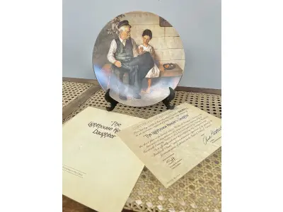 LOTE 112 - 01 PRATO NORMAN ROCKWELL.UM PEDAÇO DA HISTÓRIA AMERICANA COM ESTE PRATO DE COLECIONADOR DE EDIÇÃO LIMITADA, COM UMA BELA ILUSTRAÇÃO DE NORMAN ROCKWELL DE 1979. ESTE PRATO RETRATA LIGHTHOUSE KEEPER’S DAUGHTER "A FILHA DO FAROLEIRO" E É FEITO NOS ESTADOS UNIDOS. PERFEITO PARA FÃS DA ICÔNICA OBRA DE ROCKWELL, ESTE PRATO DE COLECIONADOR É UM ITEM ESSENCIAL PARA QUALQUER COLEÇÃO. ADICIONE ESTA PEÇA DESLUMBRANTE À SUA COLEÇÃO HOJE MESMO E ADMIRE OS DETALHES COMPLEXOS E AS BELAS CORES QUE FAZEM DESTE PRATO UMA OBRA DE ARTE. COM CERTIFICADO DE AUTENTICIDADE. ITEM COMPRADO E GARAGENS DE ANTIGUIDADES NOS EUA.SUPORTE PARA PRATO NÃO INCLUÍDO NESTA VENDA. (NO ESTADO) ATENÇÃO! FAZER A VISITAÇÃO ANTES DE ARREMATAR, NÃO SABEMOS SE FUNCIONA, LEILÃO NÃO TEM GARANTIA E NEM DEVOLUÇÃO, SUJEITO A POSSÍVEIS AVARIAS VISÍVEIS/OCULTAS E/OU AUSÊNCIA DE COMPONENTES.