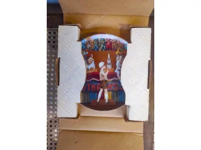 LOTE 169 - 01 RARO CHARMOSO PRATO DE COLECIONADOR DE TOM NEWSOM INTITULADO "KNOCK 'EM DOWN!", A PRIMEIRA EDIÇÃO DA SÉRIE "THE CARNIVAL". ESTE PRATO, EDIÇÃO LIMITADA E NUMERADO À MÃO, ESTÁ EM EXCELENTE ESTADO DE CONSERVAÇÃO E TEM UM DIÂMETRO DE APROXIMADAMENTE 21 CM. NUMERO DO PRATO E 68 UNS DOS PRIMEIROS LANÇAMENTOS DE UMA TIRAGEM DE 19.500.COMO VOCÊ PODE VER NAS FOTOS, AS CORES SÃO VIBRANTES E A ATENÇÃO AOS DETALHES É PRIMOROSA, TORNANDO ESTE PRATO UMA ÓTIMA OPÇÃO DE PRESENTE OU UM BELO ITEM PARA COLECIONADORES.SUPORTE DO PRATO NÃO ESTÁ INCLUÍDO. ITEM COMPRADO EM GARAGENS DE ANTIGUIDADES NOS EUA. (NO ESTADO) ATENÇÃO! FAZER A VISITAÇÃO ANTES DE ARREMATAR, NÃO SABEMOS SE FUNCIONA, LEILÃO NÃO TEM GARANTIA E NEM DEVOLUÇÃO, SUJEITO A POSSÍVEIS AVARIAS VISÍVEIS/OCULTAS E/OU AUSÊNCIA DE COMPONENTES.