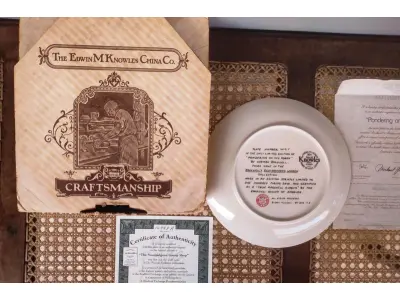 LOTE 125 - 01 PRATO DE NORMAN ROCKWELL EDIÇÃO LIMITADA "A 100 DIAS DE QUEIMA DE ESTOQUE" DA SÉRIE MULHERES REDESCOBERTAS, "PONDERING ON THE PORCH"3º PRATO DA SÉRIE MULHERES REDESCOBERTAS,21,5 CM DE DIÂMETRO, BRADEX Nº 84-R70-4.3 1981 EDWIN M. KNOWLES CHINA COMPANY UM GENUÍNO CLÁSSICO ROCKWELL. FINA EDWIN M KNOWLES. COM CERTIFICADO DE AUTENTICIDADE, FEITO NOS ESTADOS UNIDOS. PERFEITO PARA FÃS DA ICÔNICA OBRA DE ROCKWELL, ESTE PRATO DE COLECIONADOR É UM ITEM ESSENCIAL PARA QUALQUER COLEÇÃO. ADICIONE ESTA PEÇA DESLUMBRANTE À SUA COLEÇÃO HOJE MESMO E ADMIRE OS DETALHES COMPLEXOS E AS BELAS CORES QUE FAZEM DESTE PRATO UMA OBRA DE ARTE. COM CERTIFICADO DE AUTENTICIDADE. ITEM COMPRADO E GARAGENS DE ANTIGUIDADES NOS EUA.SUPORTE PARA PRATO NÃO INCLUÍDO NESTA VENDA. (NO ESTADO) ATENÇÃO! FAZER A VISITAÇÃO ANTES DE ARREMATAR, NÃO SABEMOS SE FUNCIONA, LEILÃO NÃO TEM GARANTIA E NEM DEVOLUÇÃO, SUJEITO A POSSÍVEIS AVARIAS VISÍVEIS/OCULTAS E/OU AUSÊNCIA DE COMPONENTES.