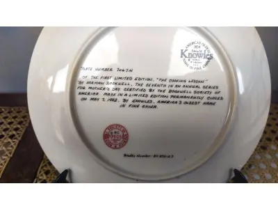 LOTE 179 - 01 PRATO DE NORMAN ROCKWELL PARA O DIA DAS MÃES DE 1982, "THE COOKING LESSON", DA PORCELANA FINA KNOWLES. O NÚMERO DO PRATO É 13025N , DA PRIMEIRA EDIÇÃO LIMITADA. O SÉTIMO DE UMA SÉRIE ANUAL PARA O DIA DAS MÃES. CERTIFICADO PELA ROCKWELL SOCIETY OF AMERICA. ESTE PRATO É UMA EDIÇÃO LIMITADA, PERMANENTEMENTE FECHADA, FEITA EM 7 DE MAIO DE 1982 PELA KNOWLES, A MARCA MAIS ANTIGA DA AMÉRICA EM PORCELANA FINA. O PRATO MEDE 21,8 CM DE DIÂMETRO E ESTÁ EM ÓTIMO ESTADO ITEM COMPRADO EM 2/10/1982 COM CERTIFICADO DE AUTENTICIDADE NOTAS E DOCUMENTOS DE COMPRA.  ITEM COMPRADO EM GARAGENS DE ANTIGUIDADES NOS EUA.SUPORTE PARA PRATO NÃO INCLUÍDO NESTA VENDA. (NO ESTADO) ATENÇÃO! FAZER A VISITAÇÃO ANTES DE ARREMATAR, NÃO SABEMOS SE FUNCIONA, LEILÃO NÃO TEM GARANTIA E NEM DEVOLUÇÃO, SUJEITO A POSSÍVEIS AVARIAS VISÍVEIS/OCULTAS E/OU AUSÊNCIA DE COMPONENTES.