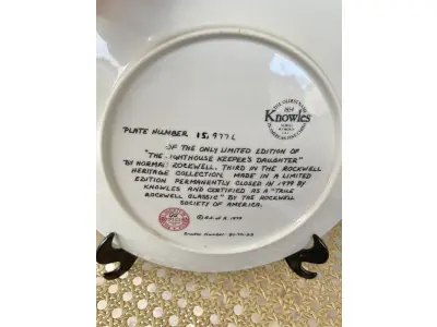 LOTE 112 - 01 PRATO NORMAN ROCKWELL.UM PEDAÇO DA HISTÓRIA AMERICANA COM ESTE PRATO DE COLECIONADOR DE EDIÇÃO LIMITADA, COM UMA BELA ILUSTRAÇÃO DE NORMAN ROCKWELL DE 1979. ESTE PRATO RETRATA LIGHTHOUSE KEEPER’S DAUGHTER "A FILHA DO FAROLEIRO" E É FEITO NOS ESTADOS UNIDOS. PERFEITO PARA FÃS DA ICÔNICA OBRA DE ROCKWELL, ESTE PRATO DE COLECIONADOR É UM ITEM ESSENCIAL PARA QUALQUER COLEÇÃO. ADICIONE ESTA PEÇA DESLUMBRANTE À SUA COLEÇÃO HOJE MESMO E ADMIRE OS DETALHES COMPLEXOS E AS BELAS CORES QUE FAZEM DESTE PRATO UMA OBRA DE ARTE. COM CERTIFICADO DE AUTENTICIDADE. ITEM COMPRADO E GARAGENS DE ANTIGUIDADES NOS EUA.SUPORTE PARA PRATO NÃO INCLUÍDO NESTA VENDA. (NO ESTADO) ATENÇÃO! FAZER A VISITAÇÃO ANTES DE ARREMATAR, NÃO SABEMOS SE FUNCIONA, LEILÃO NÃO TEM GARANTIA E NEM DEVOLUÇÃO, SUJEITO A POSSÍVEIS AVARIAS VISÍVEIS/OCULTAS E/OU AUSÊNCIA DE COMPONENTES.