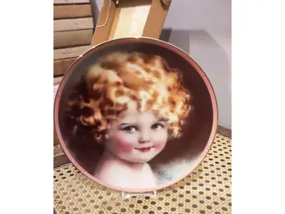 LOTE 298 - 01 RARO PRATO DE PORCELANA SUNBEAM DE COLECIONADOR DE 1986, COM BELO CAMAFEU DE BESSIE PEASE GUTMAN, RETRATO PRECIOSO, ASSINADO E NUMERADO. MEDE APROXIMADAMENTE 21 CM DE DIÂMETRO. O PRATO DA COLEÇÃO HAMILTON, NÚMERO 2115R. ESTE PRATO DE COLECIONADOR VINTAGE SUNBEAM DE 1986 DA COLEÇÃO HAMAMTON É UM ITEM ESSENCIAL PARA QUALQUER COLECIONADOR DE CULTURA AMERICANA. É A PRIMEIRA EDIÇÃO DOS PRECIOUS PORTRAITS E É AUTENTICAMENTE NUMERADA 2115R. ESTE PRATO É FEITO DE PORCELANA DE ALTA QUALIDADE E APRESENTA UMA BELA E VIBRANTE IMAGEM MULTICOLORIDA DE UMA JOVEM, ADICIONANDO UM TOQUE DE ELEGÂNCIA A QUALQUER COLEÇÃO DECORATIVA.POSSUI A CAIXA ORIGINAL CERTIFICADO DE AUTENTICIDADE E OS DOCUMENTOS.O SUPORTE DO PRATO NÃO ESTÁ INCLUÍDO. PEÇA COMPRADA EM GARAGEM DE ANTIGUIDADES NOS EUA. SUPORTE PARA PRATO NÃO INCLUÍDO NESTA VENDA. (NO ESTADO) ATENÇÃO! FAZER A VISITAÇÃO ANTES DE ARREMATAR, NÃO SABEMOS SE FUNCIONA, LEILÃO NÃO TEM GARANTIA E NEM DEVOLUÇÃO, SUJEITO A POSSÍVEIS AVARIAS VISÍVEIS/OCULTAS E/OU AUSÊNCIA DE COMPONENTES.