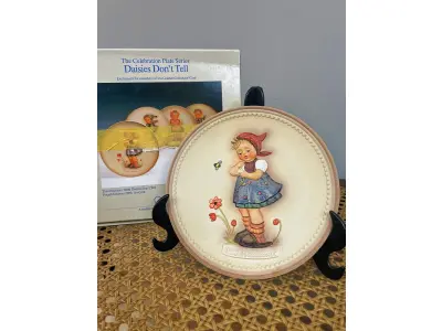 LOTE 313 - 01 RARO PRATO DE PORCELANA LINDAMENTE TRABALHADO DA FAMOSA M.J. HUMMEL GOEBEL APRESENTA UM FORMATO REDONDO E DESIGN MULTICOLORIDO, PERFEITO PARA TODAS AS OCASIÕES E ESTILOS DE DECORAÇÃO. É UM ITEM DE COLECIONADOR DA SEGUNDA EDIÇÃO DO PRATO VALENTINE JOY, GRAVADO COM DETALHES INTRINCADOS E FABRICADO NA ALEMANHA NA DÉCADA DE 1980.TERCEIRA EDIÇÃO DE UMA SÉRIE DE QUATRO PRATOS LANÇADOS PEÇA ÚNICA DA CULTURA ALEMÃ E VEM DA FRANQUIA GOEBEL, COM 16 CM DE DIÂMETROUMA MARCA RENOMADA NO SETOR DE COLECIONÁVEIS ​​DECORATIVOS. LANÇADA SOMENTE PARA MEMBROS DO CLUBE DE COLECIONADORES GOEBEL. ITEM COMPRADO EM GARAGENS DE ANTIGUIDADES NOS EUA.SUPORTE PARA PRATO NÃO INCLUÍDO NESTA VENDA. (NO ESTADO) ATENÇÃO! FAZER A VISITAÇÃO ANTES DE ARREMATAR, NÃO SABEMOS SE FUNCIONA, LEILÃO NÃO TEM GARANTIA E NEM DEVOLUÇÃO, SUJEITO A POSSÍVEIS AVARIAS VISÍVEIS/OCULTAS E/OU AUSÊNCIA DE COMPONENTES.