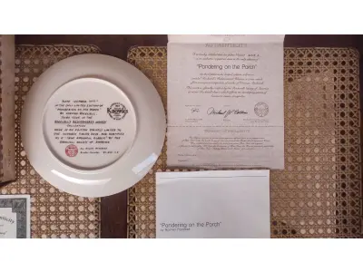 LOTE 125 - 01 PRATO DE NORMAN ROCKWELL EDIÇÃO LIMITADA "A 100 DIAS DE QUEIMA DE ESTOQUE" DA SÉRIE MULHERES REDESCOBERTAS, "PONDERING ON THE PORCH"3º PRATO DA SÉRIE MULHERES REDESCOBERTAS,21,5 CM DE DIÂMETRO, BRADEX Nº 84-R70-4.3 1981 EDWIN M. KNOWLES CHINA COMPANY UM GENUÍNO CLÁSSICO ROCKWELL. FINA EDWIN M KNOWLES. COM CERTIFICADO DE AUTENTICIDADE, FEITO NOS ESTADOS UNIDOS. PERFEITO PARA FÃS DA ICÔNICA OBRA DE ROCKWELL, ESTE PRATO DE COLECIONADOR É UM ITEM ESSENCIAL PARA QUALQUER COLEÇÃO. ADICIONE ESTA PEÇA DESLUMBRANTE À SUA COLEÇÃO HOJE MESMO E ADMIRE OS DETALHES COMPLEXOS E AS BELAS CORES QUE FAZEM DESTE PRATO UMA OBRA DE ARTE. COM CERTIFICADO DE AUTENTICIDADE. ITEM COMPRADO E GARAGENS DE ANTIGUIDADES NOS EUA.SUPORTE PARA PRATO NÃO INCLUÍDO NESTA VENDA. (NO ESTADO) ATENÇÃO! FAZER A VISITAÇÃO ANTES DE ARREMATAR, NÃO SABEMOS SE FUNCIONA, LEILÃO NÃO TEM GARANTIA E NEM DEVOLUÇÃO, SUJEITO A POSSÍVEIS AVARIAS VISÍVEIS/OCULTAS E/OU AUSÊNCIA DE COMPONENTES.