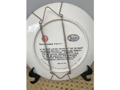 LOTE 271 - 01 PRATO THE TOY MAKER PRIMEIRO PARTO DE  ROCKWELL HERITAGE COLLECTION KNOWLES NORMAN ROCKWELL DATADO EM 1977 . ESTA É A PRIMEIRA PLACA DE COLECIONADOR DE EDIÇÃO LIMITADA Nº9857 D "THE TOY MAKER" DE NORMAN ROCKWELL NA HERITAGE COLLECTION. FOI FEITO À MÃO EM UMA EDIÇÃO LIMITADA PERMANENTEMENTE FECHADA EM 1977 POR KNOWLES E CERTIFICADA COMO "TRUE ROCKWELL CLASSIC" PELA ROCKWELL SOCIETY OF AMERICA.RETRATA UM VELHO FAZENDO UM BRINQUEDO COM UM MENINO E UMA MENINA OLHANDO ATENTAMENTE. HÁ UM CACHORRO ABAIXO DELES OLHANDO COM INTERESSE. COM TODA PAPELADA INCLUÍDA. CERTIFICADO DE AUTORIZAÇÃO DE USO (COA) E LIVRETO DE HISTÓRICO E CERTIFICADO DE AUTENTICIDADE. CAIXA ORIGINAL INCLUÍDA,. MEDE 21,5 CM DE DIÂMETRO. PROVÉM DE UMA COLEÇÃO PARTICULAR GUARDADA A ANOS NOS EUA.ITEM COMPRADO EM GARAGEM DE ANTIGUIDADES NOS EUA. SUPORTE PARA PRATO NÃO INCLUÍDO NESTA VENDA. (NO ESTADO) ATENÇÃO! FAZER A VISITAÇÃO ANTES DE ARREMATAR, NÃO SABEMOS SE FUNCIONA, LEILÃO NÃO TEM GARANTIA E NEM DEVOLUÇÃO, SUJEITO A POSSÍVEIS AVARIAS VISÍVEIS/OCULTAS E/OU AUSÊNCIA DE COMPONENTES.