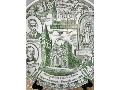 LOTE 191 - 01 RARO E BELO PRATO VERDE SOBRE BRANCO, FEITO EM 1966 PARA CELEBRAR O 75º ANIVERSÁRIO DA IGREJA UNIDA DE CRISTO DA TRINDADE EM ALLENTOWN, CONDADO DE LEHIGH, PENSILVÂNIA. INFELIZMENTE, ACREDITO QUE A IGREJA UNIDA DE CRISTO DA TRINDADE FECHOU HÁ ALGUNS ANOS, DEVIDO AO ENCOLHIMENTO DA CONGREGAÇÃO. O CONTEXTO HISTÓRICO DA IGREJA ESTÁ NO VERSO DO PRATO. O PRATO FOI FEITO PELA KETTLESPRINGS KILNS, ALLIANCE, OHIO, E TEM 25 CM DE DIÂMETRO, CÓDIGO Nº 1532.O SUPORTE DO PRATO NÃO ESTÁ INCLUÍDO. (NO ESTADO) ATENÇÃO! FAZER A VISITAÇÃO ANTES DE ARREMATAR, NÃO SABEMOS SE FUNCIONA, LEILÃO NÃO TEM GARANTIA E NEM DEVOLUÇÃO, SUJEITO A POSSÍVEIS AVARIAS VISÍVEIS/OCULTAS E/OU AUSÊNCIA DE COMPONENTES.