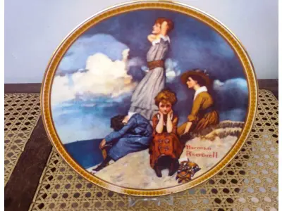 LOTE 336 - 01 PRATO DE COLECIONADOR VINTAGE NORMAN ROCKWELL "WATING ON THE SHORE" "EM PORTUGUES ESPERANDO NA PRAIA", EDIÇÃO 9 DA COLEÇÃO 'MULHERES REDESCOBERTAS DE ROCKWELL'.A ARTISTA MAIS AMADA DOS ESTADOS UNIDOS APRESENTA UMA SÉRIE INTITULADA ""MULHERES REDESCOBERTAS DE ROCKWELL"". ESTA É A NONA EDIÇÃO DA SÉRIE “TRABALHANDO NA COZINHA”.PRATO DE NUMERO 5263V DA EDIÇÃO LIMITADA. EDWIN M, KNOWLES FINE CHINA, NÚMERO BRADEX 84-R70-4.2. COM CERTIFICADO DE AUTENTICIDADE E HISTÓRICO ESCRITO DA IMAGEM DA PLACA INCLUÍDOS. COM DIÂMETRO DE 21 CM CAIXA ORIGINAL. EM EXCELENTE ESTADO. O SUPORTE DO PRATO NÃO ESTÁ INCLUÍDO. PEÇA COMPRADA EM GARAGEM DE ANTIGUIDADES NOS EUA. SUPORTE PARA PRATO NÃO INCLUÍDO NESTA VENDA." . (NO ESTADO) ATENÇÃO! FAZER A VISITAÇÃO ANTES DE ARREMATAR, NÃO SABEMOS SE FUNCIONA, LEILÃO NÃO TEM GARANTIA E NEM DEVOLUÇÃO, SUJEITO A POSSÍVEIS AVARIAS VISÍVEIS/OCULTAS E/OU AUSÊNCIA DE COMPONENTES.