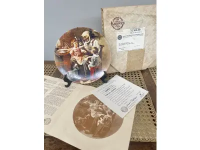 LOTE 271 - 01 PRATO THE TOY MAKER PRIMEIRO PARTO DE  ROCKWELL HERITAGE COLLECTION KNOWLES NORMAN ROCKWELL DATADO EM 1977 . ESTA É A PRIMEIRA PLACA DE COLECIONADOR DE EDIÇÃO LIMITADA Nº9857 D "THE TOY MAKER" DE NORMAN ROCKWELL NA HERITAGE COLLECTION. FOI FEITO À MÃO EM UMA EDIÇÃO LIMITADA PERMANENTEMENTE FECHADA EM 1977 POR KNOWLES E CERTIFICADA COMO "TRUE ROCKWELL CLASSIC" PELA ROCKWELL SOCIETY OF AMERICA.RETRATA UM VELHO FAZENDO UM BRINQUEDO COM UM MENINO E UMA MENINA OLHANDO ATENTAMENTE. HÁ UM CACHORRO ABAIXO DELES OLHANDO COM INTERESSE. COM TODA PAPELADA INCLUÍDA. CERTIFICADO DE AUTORIZAÇÃO DE USO (COA) E LIVRETO DE HISTÓRICO E CERTIFICADO DE AUTENTICIDADE. CAIXA ORIGINAL INCLUÍDA,. MEDE 21,5 CM DE DIÂMETRO. PROVÉM DE UMA COLEÇÃO PARTICULAR GUARDADA A ANOS NOS EUA.ITEM COMPRADO EM GARAGEM DE ANTIGUIDADES NOS EUA. SUPORTE PARA PRATO NÃO INCLUÍDO NESTA VENDA. (NO ESTADO) ATENÇÃO! FAZER A VISITAÇÃO ANTES DE ARREMATAR, NÃO SABEMOS SE FUNCIONA, LEILÃO NÃO TEM GARANTIA E NEM DEVOLUÇÃO, SUJEITO A POSSÍVEIS AVARIAS VISÍVEIS/OCULTAS E/OU AUSÊNCIA DE COMPONENTES.