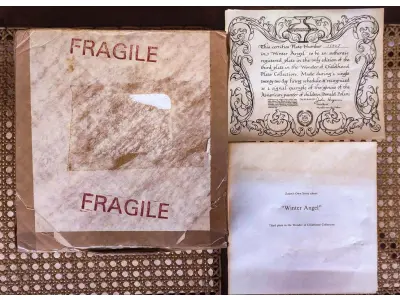 LOTE 187 - 01 RARO PRATO DE COLECIONADOR... INTITULADA "ANJO DO INVERNO"... ESTA É A PLACA NÚMERO 1592J... TERCEIRA PLACA DA COLEÇÃO MARAVILHAS DA INFÂNCIA DO AMADO PINTOR INFANTIL AMERICANO, DONALD ZOLAN  FEITA DURANTE UM PERÍODO DE QUEIMA DE 22 DIAS NO ANO DE 1984. COM DIREITOS AUTORAIS DE PEMBERTON & OAKES, 1984. COM CAIXA FOLHETO E  CERTIFICADO DE AUTENTICIDADE (COA) INCLUSOS NESTE ITEM. MEDE APROXIMADAMENTE 21 CM DE DIÂMETRO.COMPRADAS EM LOJAS DE ANTIGUIDADES DOS EUA.O SUPORTE DO PRATO NÃO ESTÁ INCLUÍDO. (NO ESTADO) ATENÇÃO! FAZER A VISITAÇÃO ANTES DE ARREMATAR, NÃO SABEMOS SE FUNCIONA, LEILÃO NÃO TEM GARANTIA E NEM DEVOLUÇÃO, SUJEITO A POSSÍVEIS AVARIAS VISÍVEIS/OCULTAS E/OU AUSÊNCIA DE COMPONENTES.