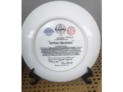 LOTE 279 - 01 LINDO PRATO COLECIONÁVEL VINTAGE DE NORMAN ROCKWELL. A SEGUNDA EDIÇÃO DE "A MIND OF HER OWN ROCKWELL'S STUDIES OF GIRLHOOD". - "SERIOUS BUSINESS" -  A CENA CAPTURA UMA JOVEM ARTISTA PINTANDO UM QUADRO. A ARTE NESTA PLACA FOI SELECIONADA E APROVADA PARA INCLUSÃO NESTA SÉRIE DE PLACAS PELO NORMAN ROCKWELL FAMILY TRUST, RECEBENDO SEU SELO DE ENDOSSO E AUTENTICAÇÃO. PINTADA POR NORMAN ROCKWELL EM 1922 E AGORA PRESERVADA EM PORCELANA FINA KNOWLES EM UMA EDIÇÃO ESTRITAMENTE LIMITADA A 150 DIAS DE QUEIMA. CERTIFICADA COMO UM VERDADEIRO CLÁSSICO ROCKWELL PELA ROCKWELL SOCIETY OF AMERICA. ESTA É OBVIAMENTE UMA JOVEM MUITO DETERMINADA. MEU PAI RESPEITAVA ESSA QUALIDADE. THOMAS ROKWELL BRADEX Nº 84-R70-9.2, PLACA NUMERADA 5662D, ILUSTRAÇÃO LINDAMENTE DETALHADA DE NORMAN ROCKWELL, PERFEITO PARA COLECIONADORES OU COMO PRESENTE,  IDEAL PARA EXIBIÇÃO EM PAREDE OU PRATELEIRA, ENRIQUEÇA SUA DECORAÇÃO OU COMECE UMA COLEÇÃO DE ARTE COM ESTA PEÇA ATEMPORAL. COM 21 CM DE DIAMETRO CAIXA E CERTIFICADO E FOLHETOS  ORIGINAIS.PEÇA COMPRADA EM GARAGEM DE ANTIGUIDADES NOS EUA. SUPORTE PARA PRATO NÃO INCLUÍDO NESTA VENDA. (NO ESTADO) ATENÇÃO! FAZER A VISITAÇÃO ANTES DE ARREMATAR, NÃO SABEMOS SE FUNCIONA, LEILÃO NÃO TEM GARANTIA E NEM DEVOLUÇÃO, SUJEITO A POSSÍVEIS AVARIAS VISÍVEIS/OCULTAS E/OU AUSÊNCIA DE COMPONENTES.