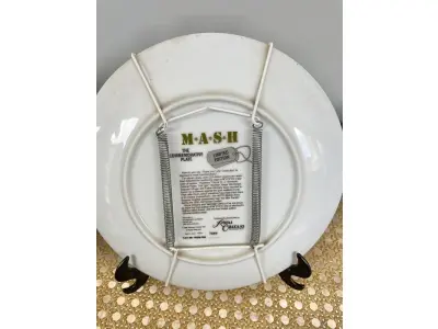 LOTE 120 - 01 LINDO PRATO DE COLECIONADOR MASH 4077ª EDIÇÃO ÚLTIMA TEMPORADA DA SÉRIE DE TELEVISÃO MASH, LIMITADA NA CAIXA ORIGINAL. COM  21,5 CM DE DIÂMETRO, FABRICADO EM 1982 PELA ROYAL ORLEANS PARA A TWENTIETH CENTURY-FOX. UM PRATO MUITO BONITO. NO VERSO, HÁ UMA LISTA COM O NOME DOS ATORES. DISTRIBUÍDO EXCLUSIVAMENTE PELA ROYAL ORLEANS, NOVA ORLEANS, LA. COM CERTIFICADO DE AUTENTICIDADE E DOCUMENTOS. ITEM COMPRADO E GARAGENS DE ANTIGUIDADES NOS EUA. SUPORTE PARA PRATO NÃO INCLUÍDO NESTA VENDA. (NO ESTADO) ATENÇÃO! FAZER A VISITAÇÃO ANTES DE ARREMATAR, NÃO SABEMOS SE FUNCIONA, LEILÃO NÃO TEM GARANTIA E NEM DEVOLUÇÃO, SUJEITO A POSSÍVEIS AVARIAS VISÍVEIS/OCULTAS E/OU AUSÊNCIA DE COMPONENTES.