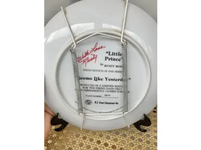 LOTE 122 - 01 PRATO DECORATIVO 'PEQUENO PRÍNCIPE' - POR RUSTY MONEY - SEXTA EDIÇÃO DA SÉRIE "PARECE ONTEM" - PRODUZIDO EM EDIÇÃO LIMITADA POR APENAS DEZ DIAS DE QUEIMA E DEPOIS FECHADO PERMANENTEMENTE - NÚMERO DA PLACA 4874, COM CAIXA ORIGINAL E CERTIFICADO DE AUTENTICIDADE. MEDE 21,5 CM DE DIÂMETRO SUPORTE PARA PRATO NÃO INCLUÍDO NESTA VENDA. (NO ESTADO) ATENÇÃO! FAZER A VISITAÇÃO ANTES DE ARREMATAR, NÃO SABEMOS SE FUNCIONA, LEILÃO NÃO TEM GARANTIA E NEM DEVOLUÇÃO, SUJEITO A POSSÍVEIS AVARIAS VISÍVEIS/OCULTAS E/OU AUSÊNCIA DE COMPONENTES.