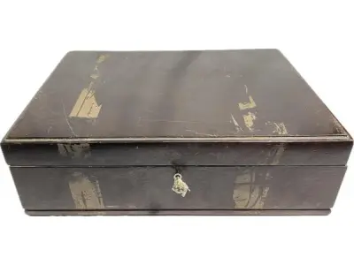 LOTE 190 - 01 ANTIGA CAIXA FAQUEIROS ARTE DÉCOR. ANOS 50, EM MADEIRA NOBRE, INTERIOR COM FORRAÇÃO EM TECIDO AVELUDADO. ACOMPANHA CHAVE. COM 18X55X42 CM. SEM CUPIM PRECISA APENAS DE UMA LIMPEZA, POIS FOI EMBALADA COM FITA MARCAS DAS FOTOS SAI FÁCIL