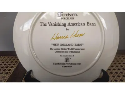 LOTE 181 - 01 RARO PRATO PORCELANA FRANCISCANA DA HISTORIC PROVIDENCE MINT WORLD PREMIER FIRST EDITION, DE 1983, DA SÉRIE THE VANISHING AMERICAN BARN, DA HARRIS HIEN, A SEGUNDA EDIÇÃO DA SÉRIE, INTITULADA "THE LOG BARN", NEW "ENGLAND BARN". O PRATO APRESENTA UMA REPRESENTAÇÃO ÚNICA, DETALHADA E COLORIDA DE UM TIPO DE CELEIRO AMERICANO, SITUADO EM UM CENÁRIO DE FAZENDA DE DIFERENTES REGIÕES DO PAÍS, COM DETALHES DOURADOS NA BORDA. ESTAMPADAS NA PARTE INFERIOR COM O NOME DA SÉRIE, TÍTULO, ASSINATURA IMPRESSA DO ARTISTA E A MARCA THE HISTORIC PROVIDENCE MINT, E MEDEM APROXIMADAMENTE 21,8 CM DE DIÂMETRO. EM EXCELENTE ESTADO, POSSUI A CAIXA ORIGINAL E OS DOCUMENTOS.O SUPORTE DO PRATO NÃO ESTÁ INCLUÍDO. (NO ESTADO) ATENÇÃO! FAZER A VISITAÇÃO ANTES DE ARREMATAR, NÃO SABEMOS SE FUNCIONA, LEILÃO NÃO TEM GARANTIA E NEM DEVOLUÇÃO, SUJEITO A POSSÍVEIS AVARIAS VISÍVEIS/OCULTAS E/OU AUSÊNCIA DE COMPONENTES.