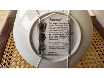 LOTE 346 - 01 PRATO COLECIONÁVEL "RAPUNZEL" DA BAVIERA, 1982, CHARLES GEHM, FADA DOS IRMÃOS GRIMM. SÉRIE DE CONTOS DE FADAS. COM 20 CM. A PEÇA FOI MANTIDA EM SUA EMBALAGEM ORIGINAL E NÃO FOI EXPOSTA. ACOMPANHA LIVRETO E CERTIFICADO DE AUTENTICIDADE. KONIGSZELT BAVIERA.ESSA E A SEGUNDA PLACA DE COLECIONADOR DA COLEÇÃO PINTADA POR CHARLES GEHM ESPECIALMENTE PARA A CIDADE DE HANAU, NA REPÚBLICA FEDERAL DA ALEMANHA, LOCAL DE NASCIMENTO DOS IRMÃOS GRIMM, PARA COMEMORAR SEU 200º ANIVERSÁRIO. PLACA DE COLECIONADOR NÚMERO D 1594.EDIÇÃO LIMITADA A CEM DIAS DE DISPARO,BRADEX-NÃO. 22-K46-2.2.ITEM COMPRADO EM GARAGENS DE ANTIGUIDADES NOS EUA. (NO ESTADO) ATENÇÃO! FAZER A VISITAÇÃO ANTES DE ARREMATAR, NÃO SABEMOS SE FUNCIONA, LEILÃO NÃO TEM GARANTIA E NEM DEVOLUÇÃO, SUJEITO A POSSÍVEIS AVARIAS VISÍVEIS/OCULTAS E/OU AUSÊNCIA DE COMPONENTES.