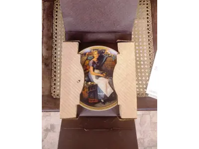 LOTE 345 - 01 LINDO PRATO VINTAGE NORMAN ROCKWELL DE 1984, "DREAMING IN THE ATTIC".EM PORTUGUES SONHANDO NO SÓTÃO. EDIÇÃO LIMITADA NUMERADA 9650S EDWIN M. KNOWLES. LIMITADO A 150 DIAS DE QUEIMA E CERTIFICADO COMO UM VERDADEIRO CLÁSSICO ROCKWELL CLASSIC. CERTIFICADO DE AUTENTICIDADE INCLUSO. COM 21,5 CM DE DIÂMETRO. COM CERTIFICADO DE AUTENTICIDADE. SUPORTE DO PRATO NÃO ESTÁ INCLUÍDO. ITEM COMPRADO EM GARAGENS DE ANTIGUIDADES NOS EUA. (NO ESTADO) ATENÇÃO! FAZER A VISITAÇÃO ANTES DE ARREMATAR, NÃO SABEMOS SE FUNCIONA, LEILÃO NÃO TEM GARANTIA E NEM DEVOLUÇÃO, SUJEITO A POSSÍVEIS AVARIAS VISÍVEIS/OCULTAS E/OU AUSÊNCIA DE COMPONENTES.