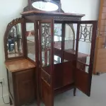 LOTE 040 - 01 CRISTALEIRA ANTIGA IMBUIA COM DETALHES ENTALHADOS NAS PORTAS, ESPELHOS LATERAIS, COM PORTA ENVIDRAÇADA EM CRISTAL BISOTADO. (NO ESTADO DE CONSERVAÇÃO QUE SE ENCONTRA) 