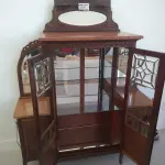 LOTE 040 - 01 CRISTALEIRA ANTIGA IMBUIA COM DETALHES ENTALHADOS NAS PORTAS, ESPELHOS LATERAIS, COM PORTA ENVIDRAÇADA EM CRISTAL BISOTADO. (NO ESTADO DE CONSERVAÇÃO QUE SE ENCONTRA) 