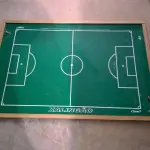 LOTE 015 - 02 (DOIS) QUADROS PINTURA DE “BAIANA”, 01 (UM) MINI QUADRO DE GIRASSOL E 01 QUADRO PARA FUTEBOL DE BOTÃO MARCA XALINGÃ.(NO ESTADO)