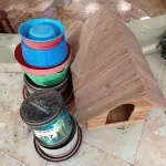 LOTE 267 - 01 CASINHA EM MADEIRA PARA CACHORRO E VASILHAS PLÁSTICA PARA PLANTAS (NO ESTADO, NÃO SABEMOS SE FUNCIONA. LEILÃO NÃO TEM GARANTIA E NEM DEVOLUÇÃO).