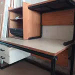 LOTE 444 - 02 MESAS COM ESTRUTURA EM FERRO FUNDIDO TAMPO EM MADEIRA SENDO 01 SEM GAVETAS E 01 ARMÁRIO EM MADEIRA COM PORTA DE ENROLAR. (NO ESTADO, LEILÃO NÃO TEM GARANTIA E NEM DEVOLUÇÃO, SUJEITO A POSSÍVEIS AVARIAS VISÍVEIS/OCULTAS E/OU AUSÊNCIA DE COMPONENTES).