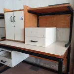 LOTE 439 - 02 MESAS COM ESTRUTURA EM FERRO FUNDIDO TAMPO EM MADEIRA SENDO 01 SEM GAVETAS, 01 GAVETEIRO COM 02 GAVETAS E 01 ARMÁRIO EM MADEIRA COM 02 PORTAS. (NO ESTADO, LEILÃO NÃO TEM GARANTIA E NEM DEVOLUÇÃO, SUJEITO A POSSÍVEIS AVARIAS VISÍVEIS/OCULTAS E/OU AUSÊNCIA DE COMPONENTES).