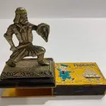 LOTE 035 - ANTIGO PORTA CAIXA FOSFORO SAMURAI DE METAL (NO ESTADO)