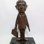 LOTE 008 - MINI ESCULTURA DE BRONZE NA BASE DE   MÁRMORE, MR. BEAN.  19CM (NO ESTADO)