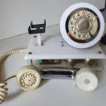 LOTE 084 - RARO TELEFONE ANOS 70. EM PLÁSTICO CROMADO E MECANISMO EM CAIXA DE ACRÍLICO MEDIDAS 24 CM COMP X 14,5 CM LARG X 19 CM ALT (NO ESTADO)