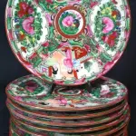 LOTE 123 - LINDÍSSIMO E RARO CONJUNTO CHINES, SÉC XIX PERÍODO " TAO KUANG ", AO GOSTO FAMÍLIA ROSA, SÃO 12 PRATOS PARA BOLO, EM PORCELANA  ESMALTADA A MÃO, PADRÃO MANDARIM. COM SELO VERMELHO. MED 16 CM.(NO ESTADO)