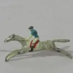 LOTE 078 - COLEÇÃO COM 20  MINIATURAS DE CAVALOS DE CORRIDA ANTIGOS DÉCADA DE 80 COM  JÓQUEIS EM CHUMBO, POLICROMADA, NO ESTOJO DE MADEIRA COM DIVISÓRIAS OBS DUAS MINIATURAS FALTANDO UMA PERNA (NO ESTADO)
