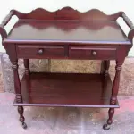 LOTE 114 - RARO E LINDO CARRINHO DE CHÁ, MADEIRA MACIÇA, TORNEADAS, PRATELEIRA,  DUAS GAVETAS ALT:80 CM; LARG: 80 CM; PROF: 41 CM.(NO ESTADO)
