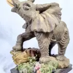 LOTE 082 - RARO ELEFANTE  AFRICANO  IMPORTADO  ITALIANO, EM RESINA POLICROMADA, BASE DE MADEIRA. MEDIDAS: 36X30X25 CM.(NO ESTADO)