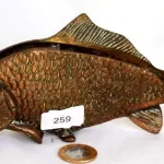 LOTE 092 - PORTA GUARDANAPOS, PRODUZIDO EM BRONZE, PEIXE, MAIOR COMPRIMENTO 21,5 CM.(NO ESTADO)