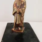 LOTE 081 - ESCULTURA  MAGISTRADO ALT.: 11 CM, BASE DE PEDRA FORMA DE LIVRO, DIM.: 2X9X12,5 CM  EM BRONZE MACIÇO (NO ESTADO)