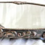 LOTE 065 - BANDEJA ESPESSURADO À PRATA, COM ESPELHO 38 CM, ESPELHO COM MARCAS DO TEMPO. (NO ESTADO)