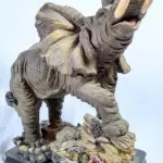 LOTE 082 - RARO ELEFANTE  AFRICANO  IMPORTADO  ITALIANO, EM RESINA POLICROMADA, BASE DE MADEIRA. MEDIDAS: 36X30X25 CM.(NO ESTADO)