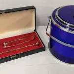 LOTE 106 - CONJUNTO DE BEBIDAS COM BALDE DE GELO COM APLIQUES DE METAL E CONJUNTO DE  SERVIÇO EM PRATA 90 COM DOSADOR, PINÇA E MISTURADOR . MARCA :  BELINI (NO ESTADO)