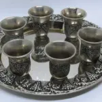 LOTE 145 - LINDA BANDEJA   COM 6 COPOS - EM METAL PRESSURIZADA A PRATA COM DETALHES DE CACHOS DE UVAS EM ALTO RELEVO MEDEM 24CM. (NO ESTADO)