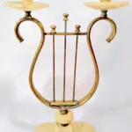LOTE 176 - RARO TERNO IMPORTADO ITÁLIA, SÉC XIX, EM ALABASTRO, PARTES  EM BRONZE DOURADO, 1 CENTRO DE MESA-FLOREIRA,  GRANDE FLOR  UM PAR DE CASTIÇAIS PRA DUAS VELAS REPRESENTANDO ARPAS. MED 17X30 CM (CENTRO DE MESA) E 35X20 CM( CASTIÇAIS). (NO ESTADO)