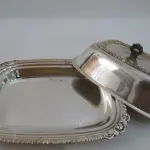 LOTE 211 - MANTEIGUEIRA EM METAL ESPESSURADO A PRATAE SINO EM METAL NIQUELADO, 11CM (NO ESTADO)